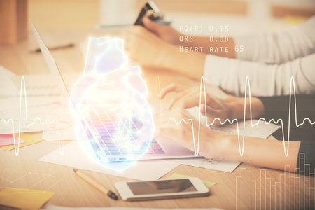 Double exposure of woman hands typing on computer and heart hologram drawing. Education concept.の写真素材