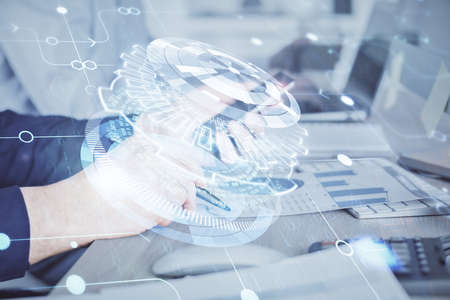 Double exposure of man's hand holding and using a digital device and data theme hologram drawing. Technology concept.の写真素材
