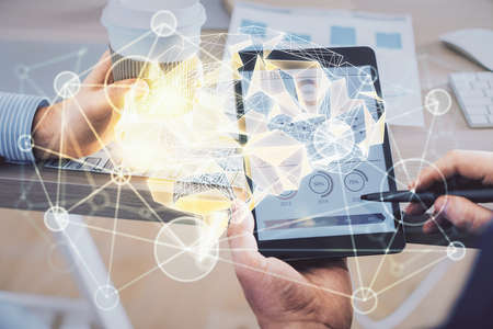 Double exposure of man's hand holding and using a digital device and brain hologram drawing. Data...