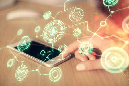 Double exposure of social network sketch hologram and woman holding and using a mobile device.