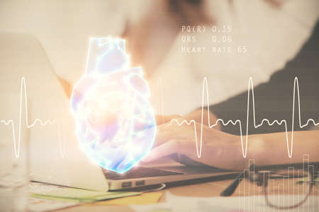 Double exposure of woman hands typing on computer and heart hologram drawing. Education concept.の写真素材