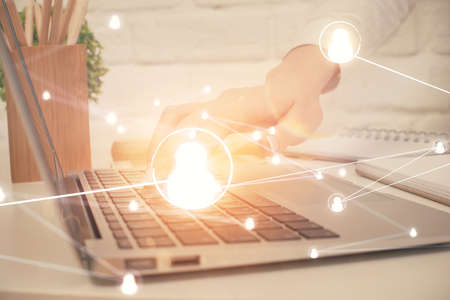 Double exposure of woman hands typing on computer and social network theme hologram drawing. People...