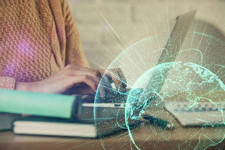 Double exposure of woman hands typing on computer and social network theme hologram drawing. People...