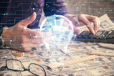 Double exposure of man's hands holding and using a digital device and bulb hologram drawing. Idea concept.の写真素材