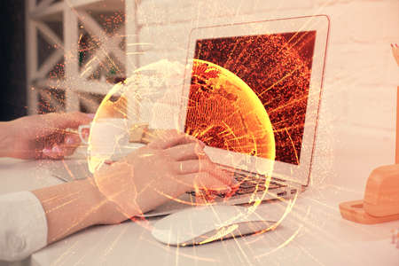 Double exposure of woman hands typing on computer and social network theme hologram drawing. People...