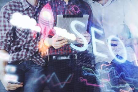 Double exposure of seo drawing and man and woman working together holding and using a mobile device....