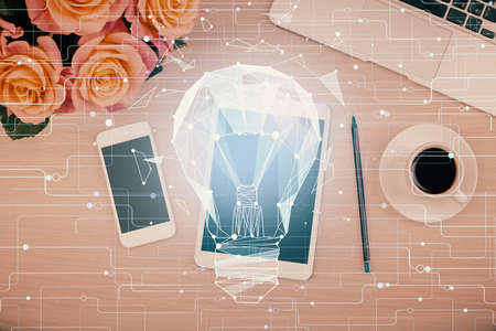 Double exposure of bulb drawing over table with phone. Top view. Concept of idea.の写真素材