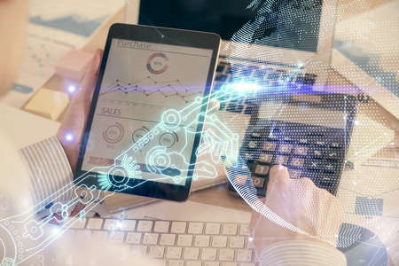 Double exposure of man's hands holding and using a digital device and tech theme hologram drawing. Technology concept.の写真素材