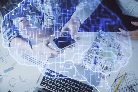 Double exposure of man and woman working together holding and using a mobile device and brain...