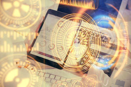 Double exposure of man's hands holding and using a digital device and tech theme hologram drawing....