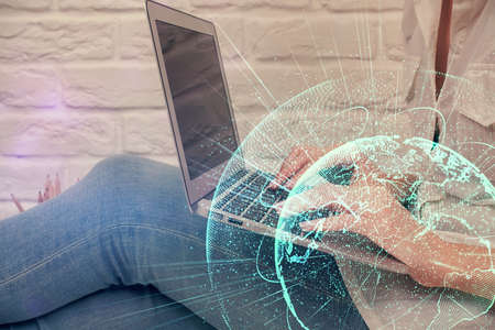 Double exposure of woman hands typing on computer and social network theme hologram drawing. People...