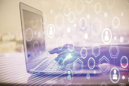 Double exposure of woman hands typing on computer and social network theme hologram drawing. People...
