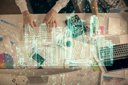 Double exposure of man and woman working together and the buildings hologram drawing. Computer...