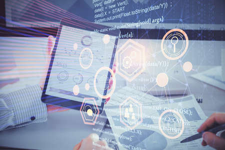 Double exposure of man's hand holding and using a digital device and data theme hologram drawing....