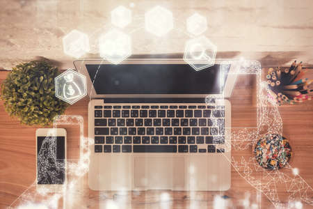 Technology hologram drawing over computer on the desktop background. Top view. Double exposure. Tech...