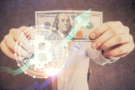 Multi exposure of blockchain theme drawing hologram and USA dollars bills and man hands. business...