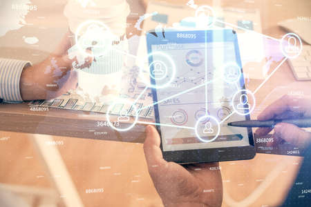 Double exposure of man's hands holding and using a phone and social network theme drawing.