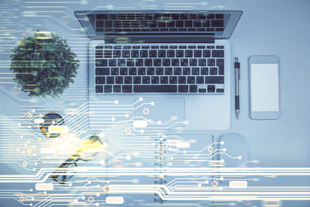 Double exposure of data drawing hologram over topview of study desk background with computer....