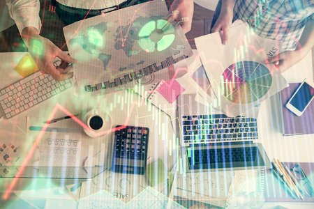 Double exposure of man and woman working together and financial chart hologram drawing. market analysis concept. Computer background. Top View.の写真素材