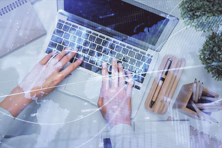 Double exposure of woman hands working on computer and forex graph hologram drawing. Top View....