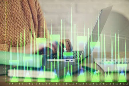 Double exposure of woman hands typing on computer and forex chart hologram drawing. Stock market...