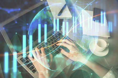 Double exposure of woman hands typing on computer and forex chart hologram drawing. Stock market...