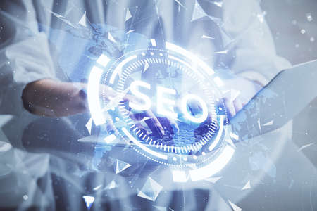 Double exposure of woman hands working on computer and seo hologram drawing. internet search...