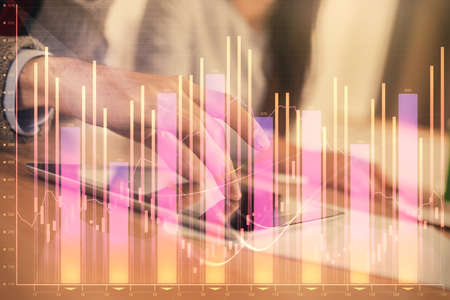 Double exposure of forex graph drawing and man and woman working together holding and using a mobile...