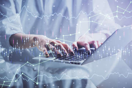 Double exposure of woman hands typing on computer and forex chart hologram drawing. Stock market invest concept.の写真素材