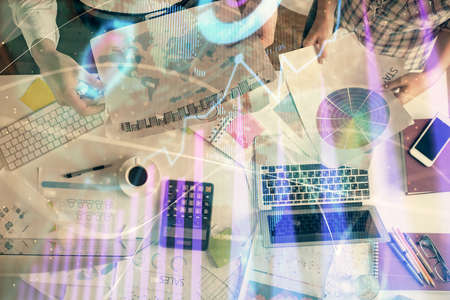 Double exposure of man and woman working together and financial chart hologram drawing. market...