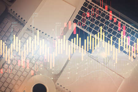 Financial market graph and top view computer on the desktop background. Multi exposure. Investment...
