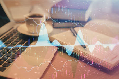 Double exposure of forex chart drawing and desktop with coffee and items on table background....