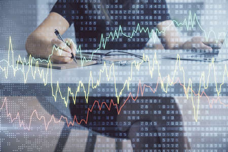 Double exposure of businesswoman hands typing on computer and forex chart hologram drawing....
