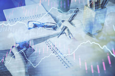 Multi exposure of woman on-line shopping holding a credit card and financial graph drawing. Stock...