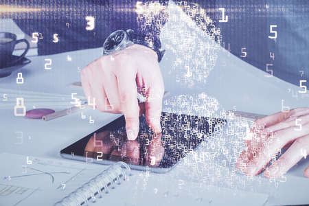 Double exposure of man's hands holding and using a digital device and tech theme hologram drawing....