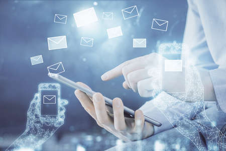Double exposure of man's hands holding and using a digital device and envelop hologram drawing....