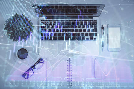 Multi exposure of forex chart drawing over table background with computer. Concept of financial...