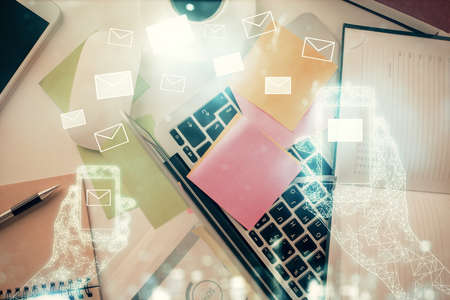Envelop hologram drawing over computer on the desktop background. Top view. Double exposure. Technology concept.の写真素材