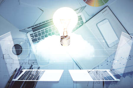 Bulb drawing over computer on the desktop background. Top view. Double exposure. Idea concept.