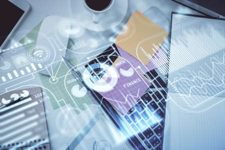 Technology hologram drawing over computer on the desktop background. Top view. Double exposure. Tech...