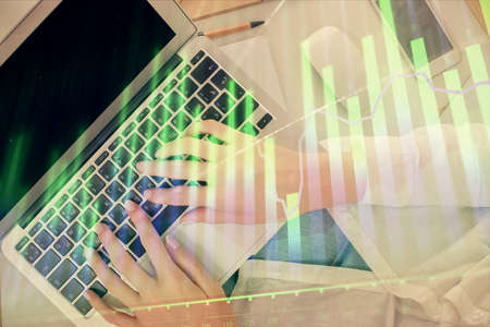 Double exposure of woman hands working on computer and forex chart hologram drawing. Top View....