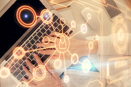 Double exposure of woman hands working on computer and social network theme hologram drawing. Top...
