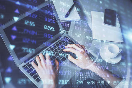 Double exposure of woman hands typing on computer and forex chart hologram drawing. Stock market...