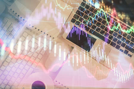 Financial market graph and top view computer on the desktop background. Multi exposure. Investment...