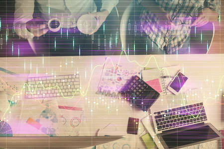 Double exposure of man and woman working together and financial chart hologram drawing. market analysis concept. Computer background. Top View.の写真素材
