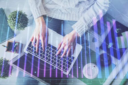Double exposure of woman hands working on computer and forex chart hologram drawing. Top View. Financial analysis concept.の写真素材