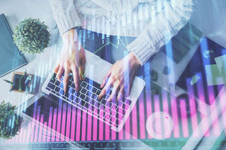 Double exposure of woman hands working on computer and forex chart hologram drawing. Top View....