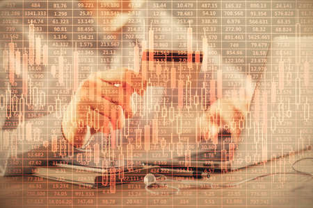 Double exposure of man hands holding a credit card and Forex graph drawing. Stock trading and...