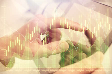 Multi exposure of man's hands holding and using a phone and financial chart drawing. Market analysis...