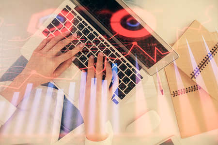 Double exposure of woman hands working on computer and forex graph hologram drawing. Top View....